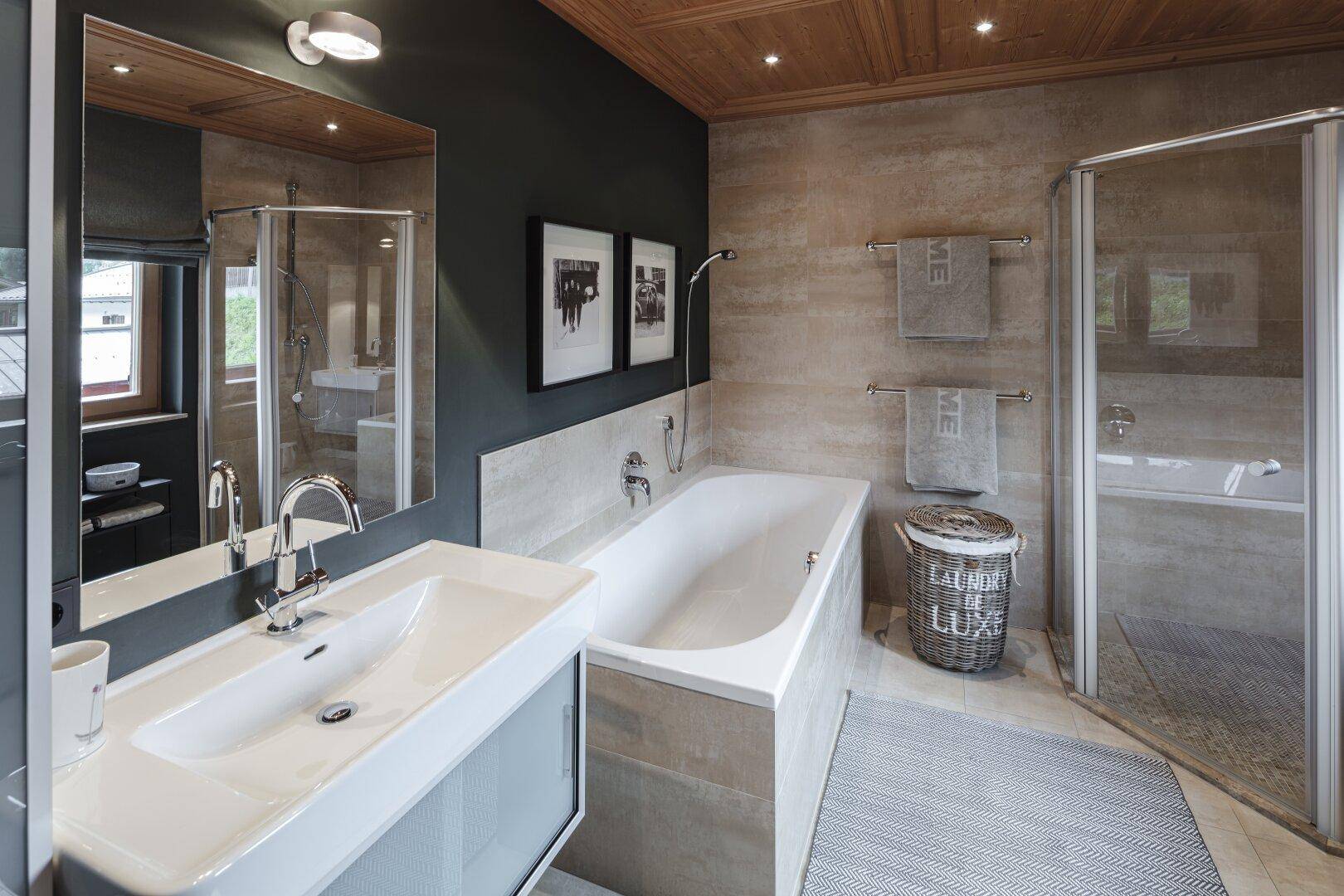 Modernes Badezimmer mit Badewanne, Dusche, Doppelwaschbecken und Fenster.