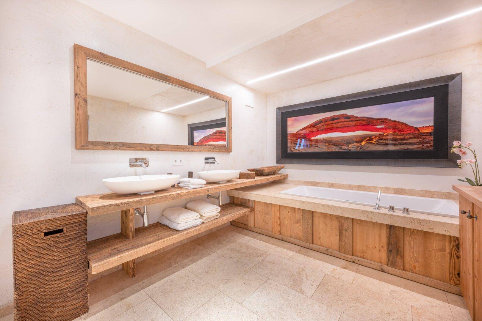 Modernes Badezimmer mit Doppelwaschbecken, Holzmöbeln und integrierter Badewanne.