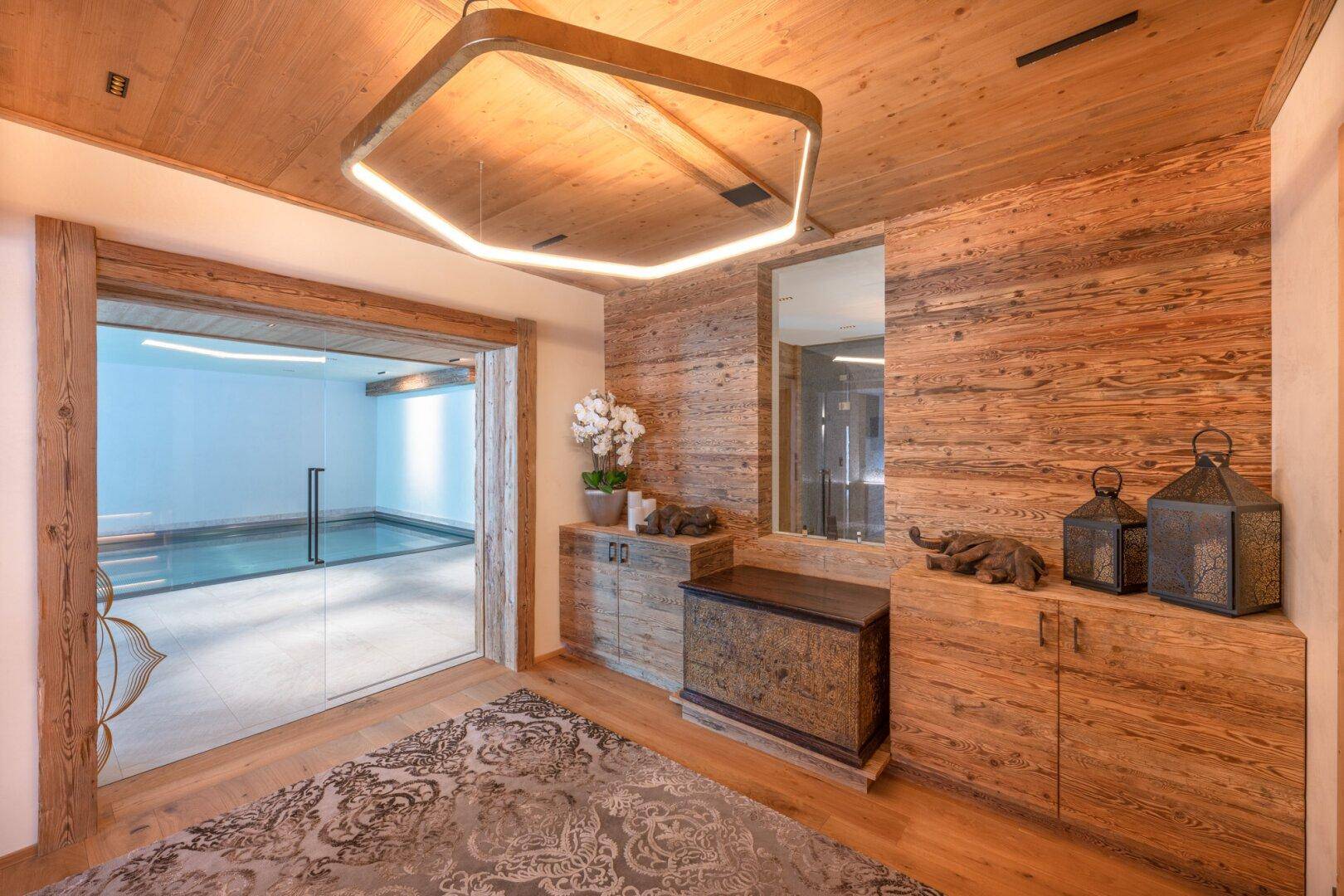 Eingangsbereich zum Wellnessbereich mit Holzwänden und moderner Beleuchtung.