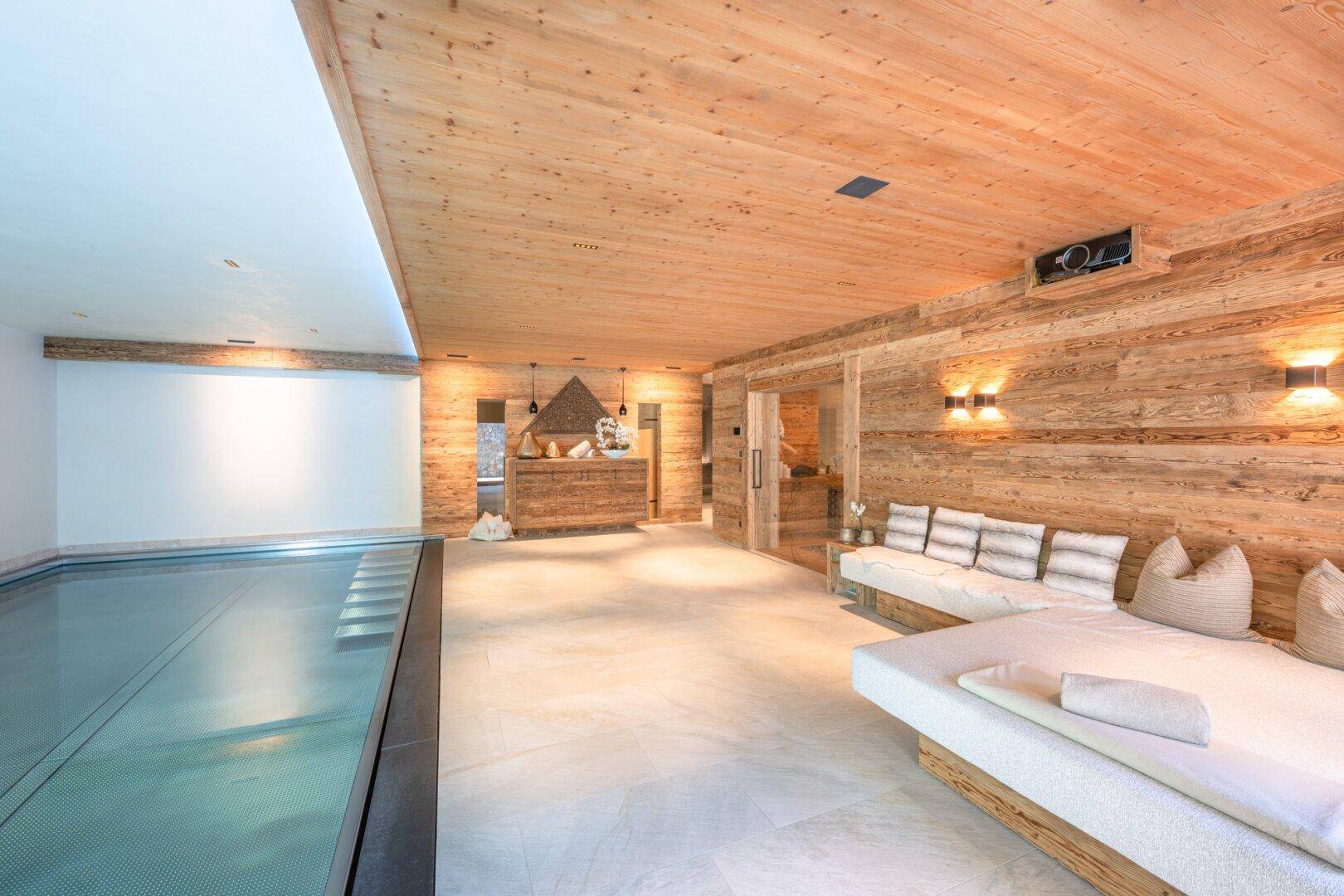 Heller Wellnessbereich mit Innenpool, bequemen Liegen und Holzelementen.
