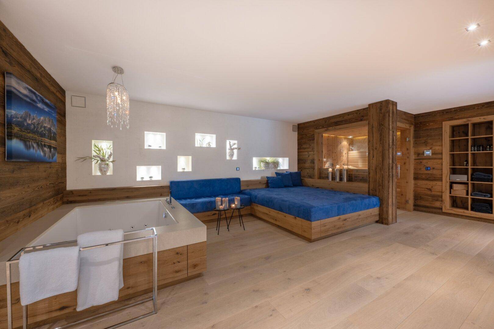 Exklusiver Wellnessbereich mit Whirlpool, Sauna und Entspannungsliegen in Holzoptik.
