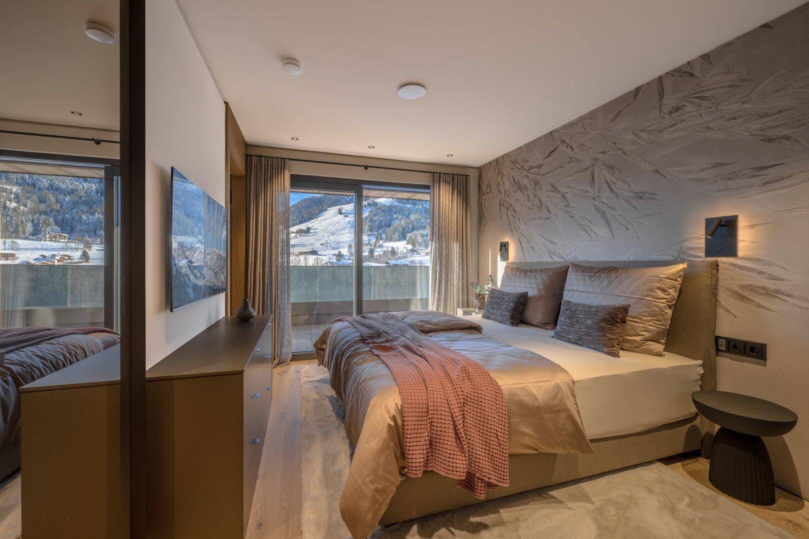 Elegantes Schlafzimmer mit Doppelbett, Holzboden und dekorativer Wandgestaltung.