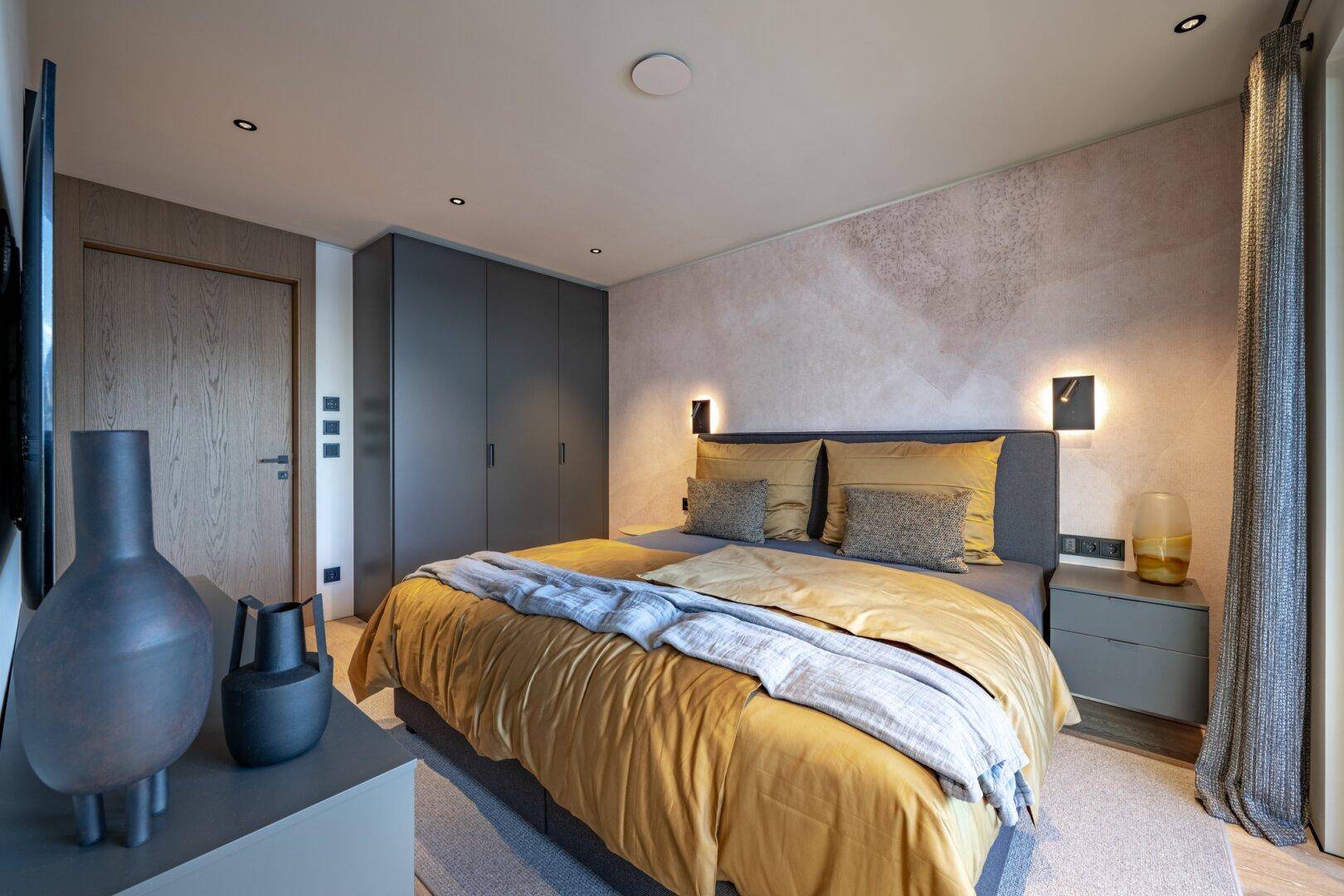 Modernes Schlafzimmer mit Doppelbett, Einbauschränken und stilvoller Dekoration.