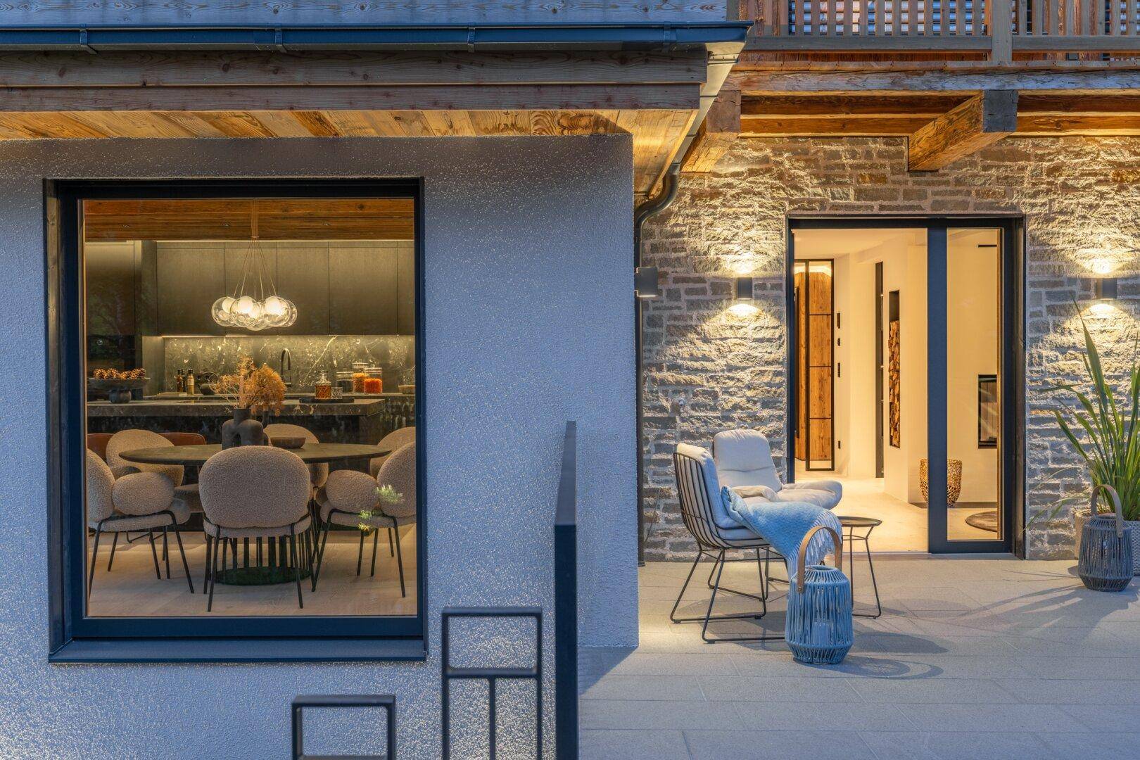 Gemütliche Terrasse mit Sitzgelegenheiten und Einblick in den eleganten Essbereich der Villa.