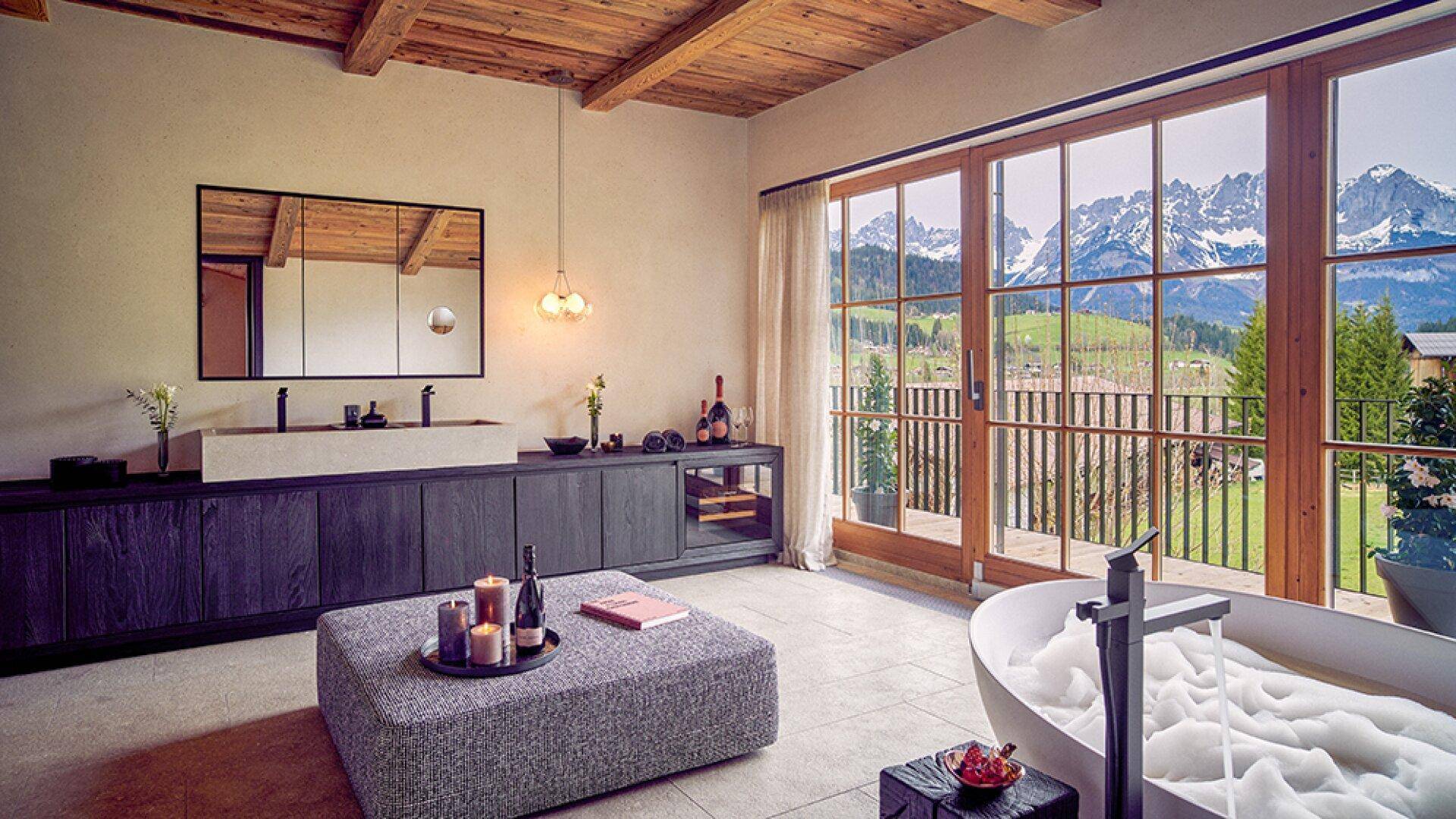 Exklusives Badezimmer mit freistehender Badewanne, Doppelwaschbecken und Panoramablick auf die Berge.