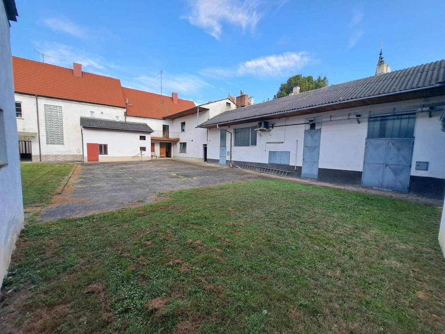 Weitläufiger Innenhof mit Rasen und Nebengebäuden, bietet viel Platz im Freien.