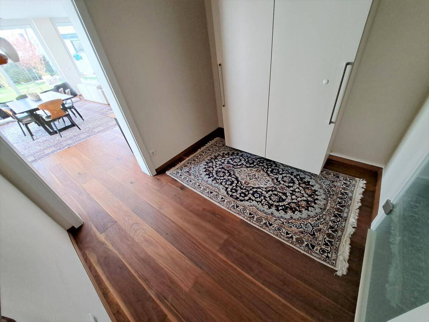 Heller Eingangsbereich mit Holzboden und integrierten Schränken.
