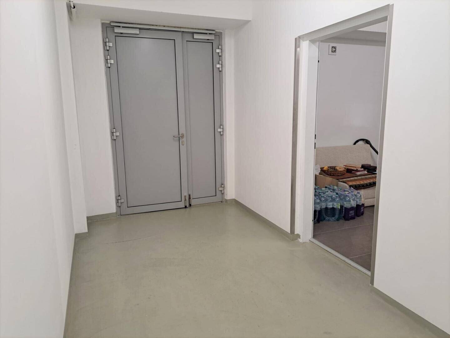 Heller Flur mit robustem Boden und Zugang zu einem Abstellraum.