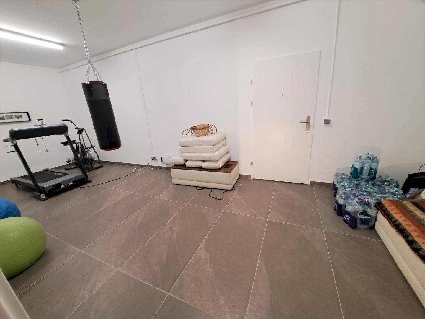 Fitnessbereich mit Boxsack und Trainingsgeräten, ideal für sportliche Aktivitäten.