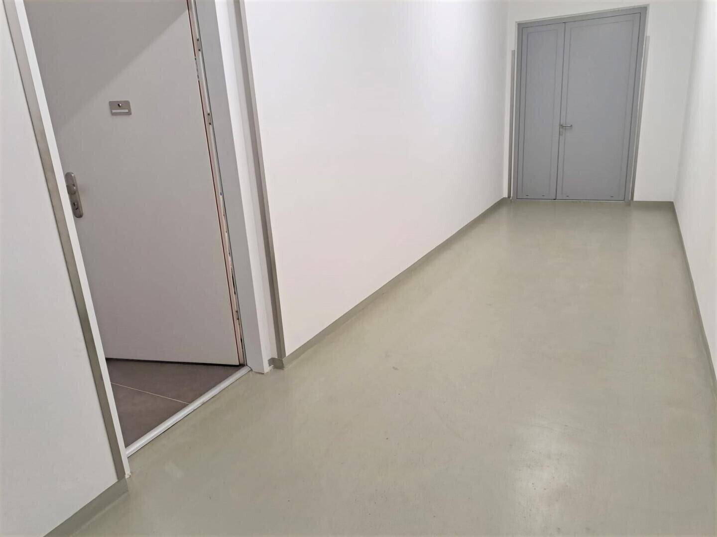 Heller Flur mit robustem Boden und Zugang zu einem Abstellraum.