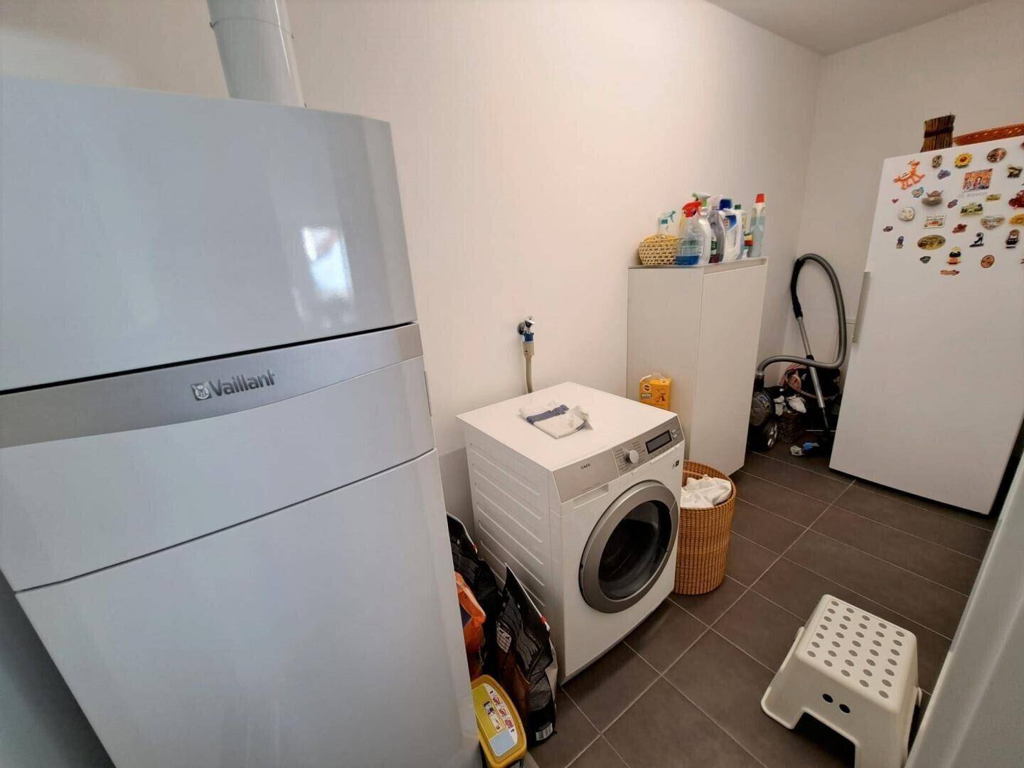 Funktionaler Hauswirtschaftsraum mit Waschmaschine, Trockner und Heizungsanlage.