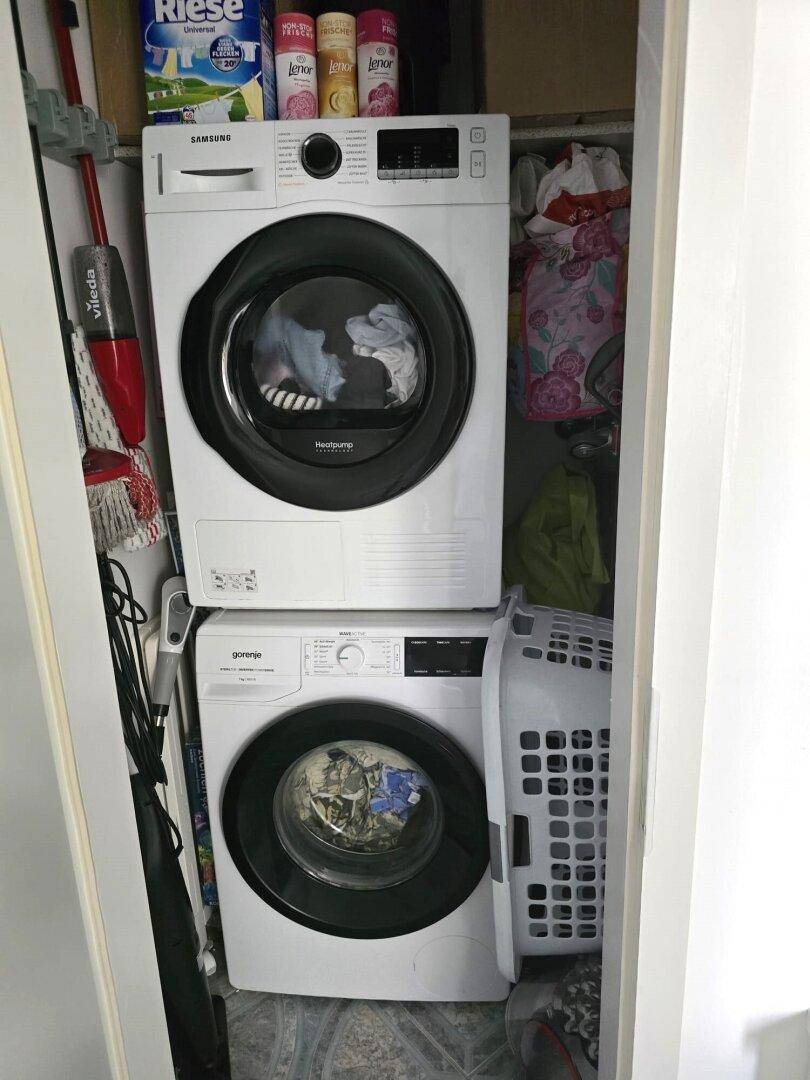 Kleiner Hauswirtschaftsraum mit gestapelter Waschmaschine und Trockner.