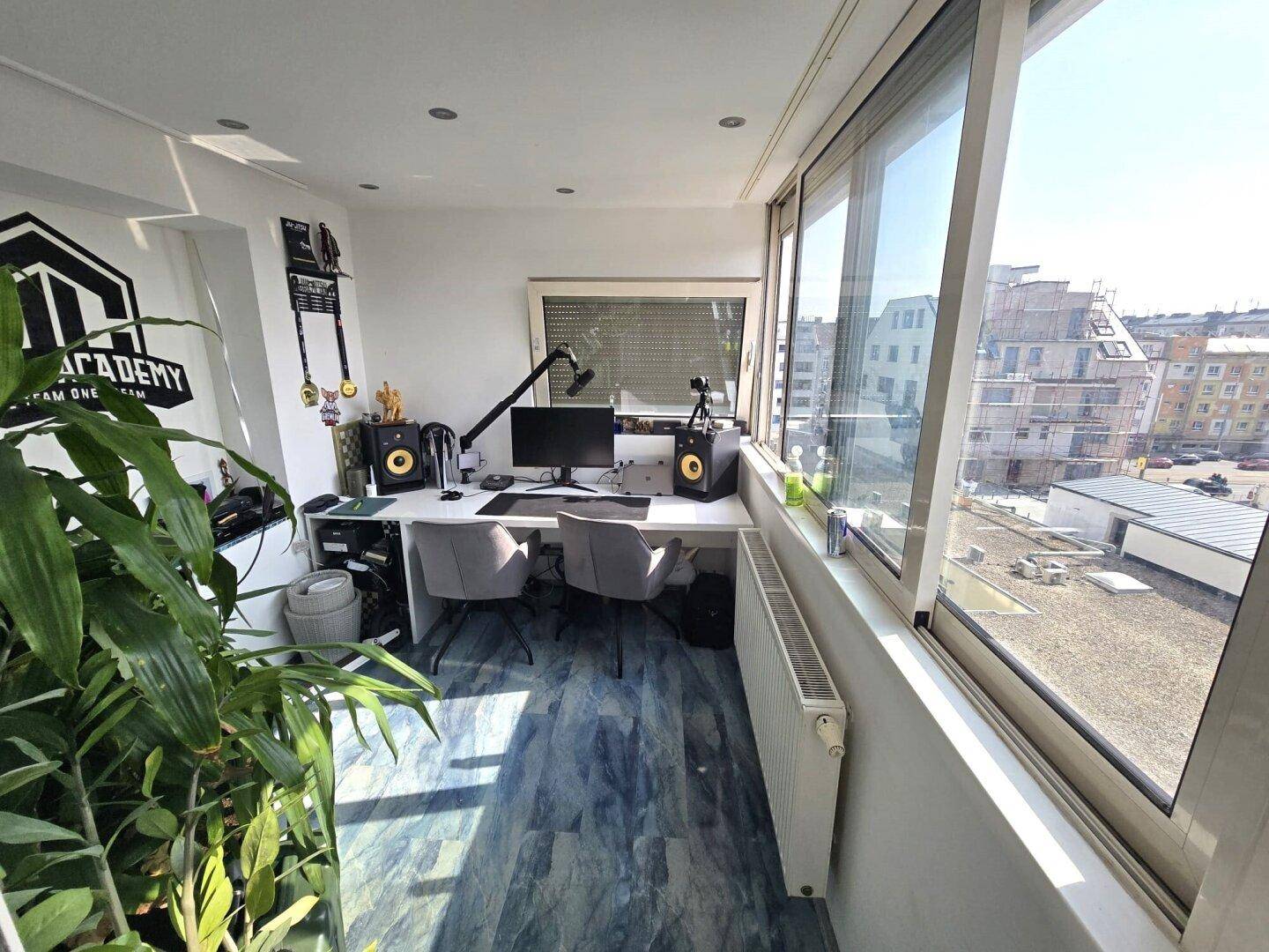 Helles Büro mit großflächigen Fenstern, modernem Schreibtisch und Blick auf die Stadt.