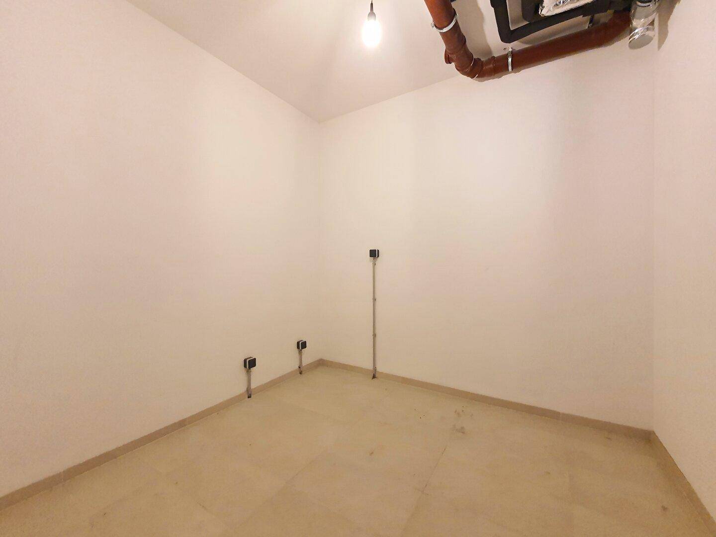 Technikraum im Keller mit sichtbaren Rohren und Anschlüssen.