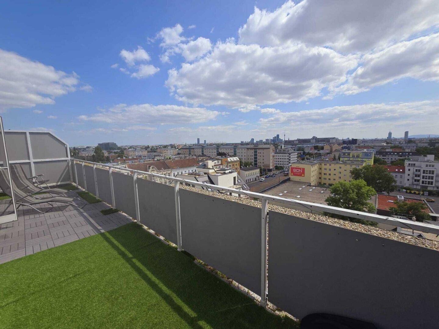 Dachterrasse mit Kunstrasen und weitem Panoramablick über die Stadt.
