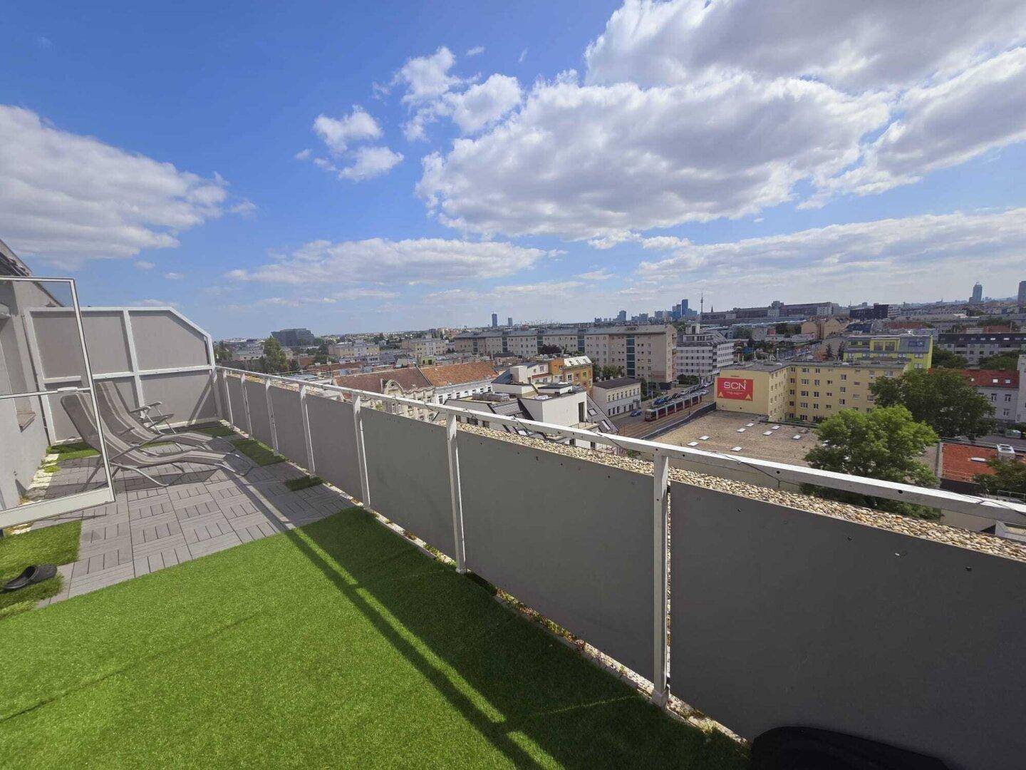 Dachterrasse mit Kunstrasen und weitem Panoramablick über die Stadt.