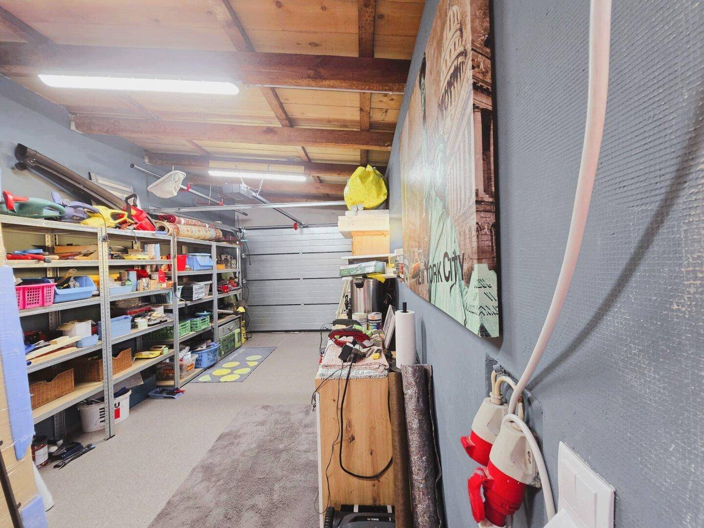 Geräumige Garage mit Regalen für Werkzeuge und Lagerung, bietet viel Platz für Fahrzeuge und Hobbys.