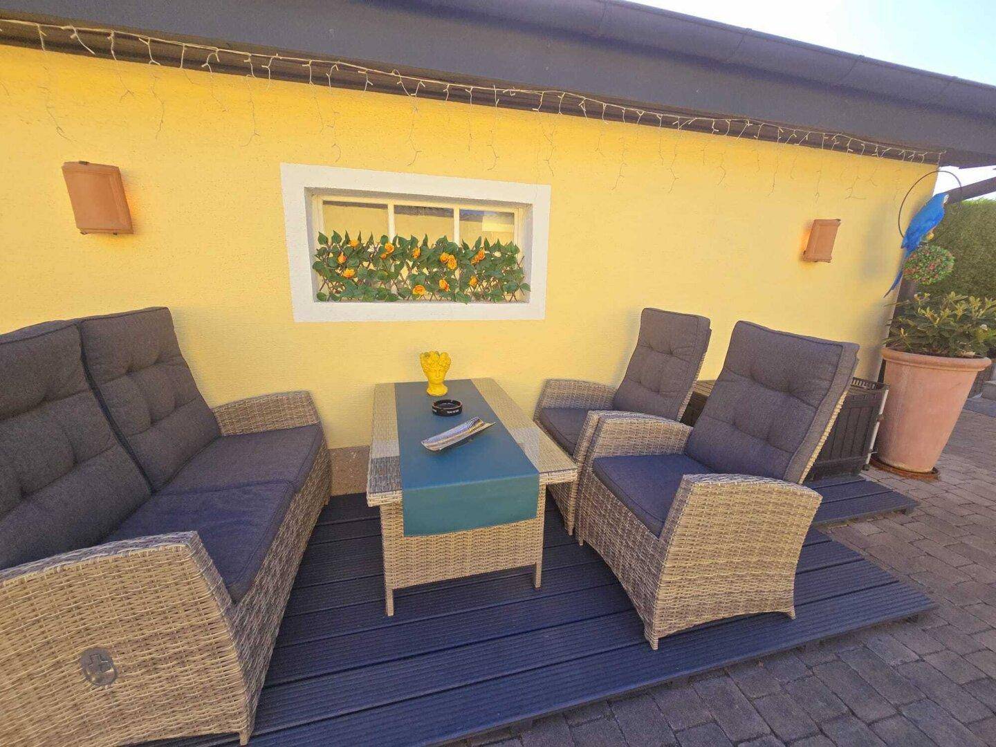 Gemütlicher Außenbereich mit Rattanmöbeln und einer kleinen Terrasse zum Entspannen.