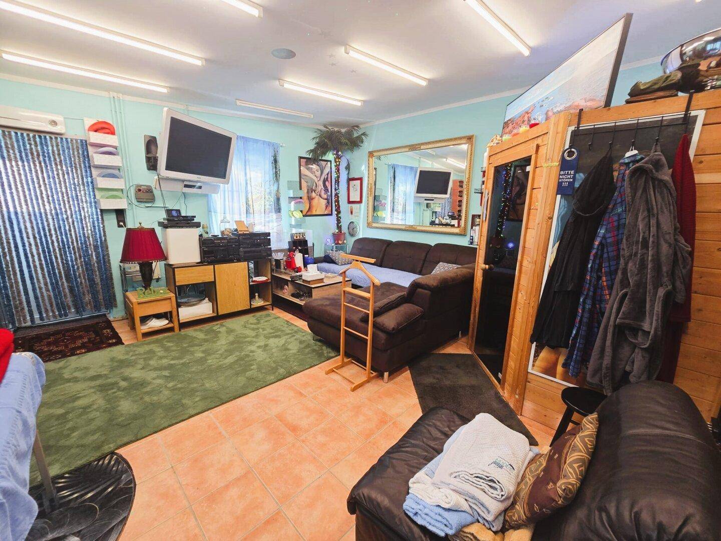 Geräumiger Wohnbereich mit großem Sofa, Spiegel und farbenfroher Dekoration, bietet viel Platz.
