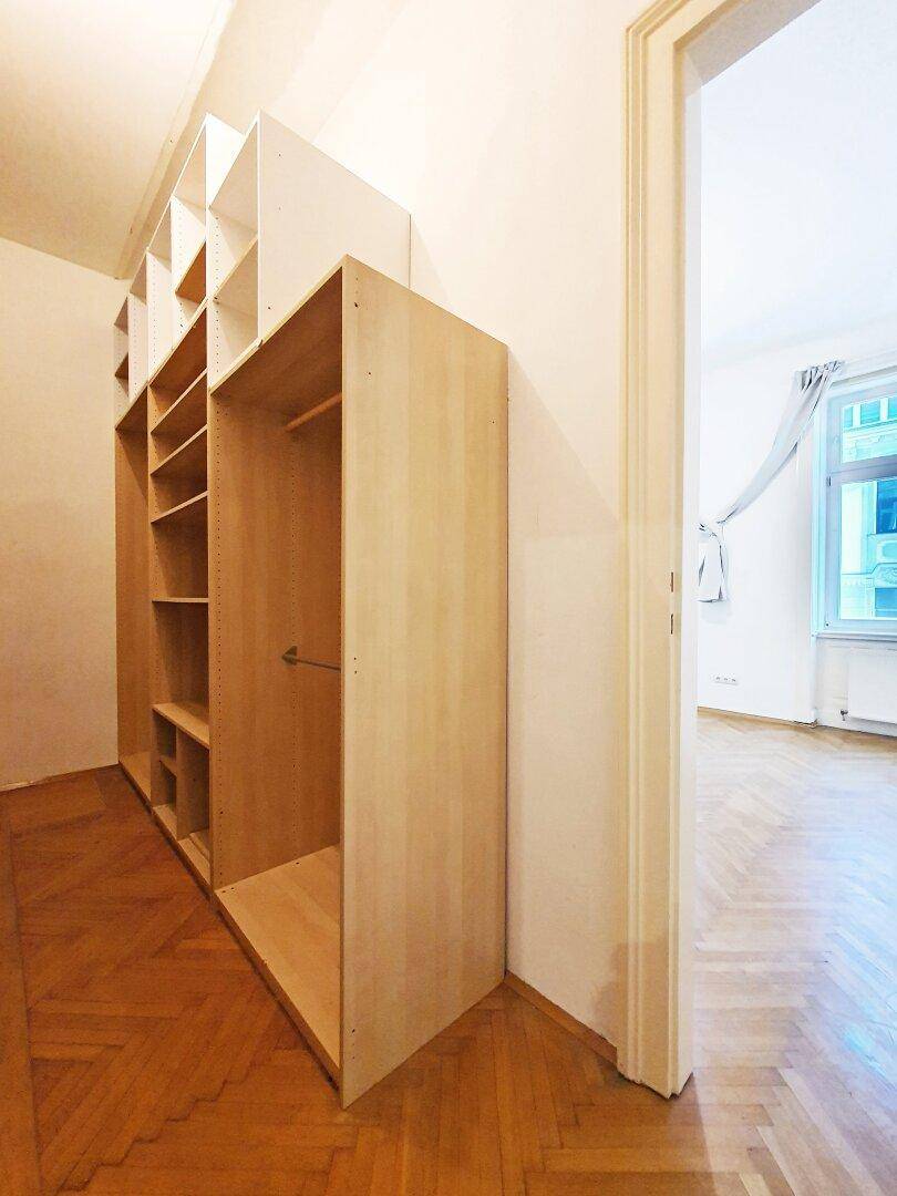 Praktischer Ankleidebereich mit offenen Regalen und Kleiderstange, der zusätzlichen Stauraum bietet.