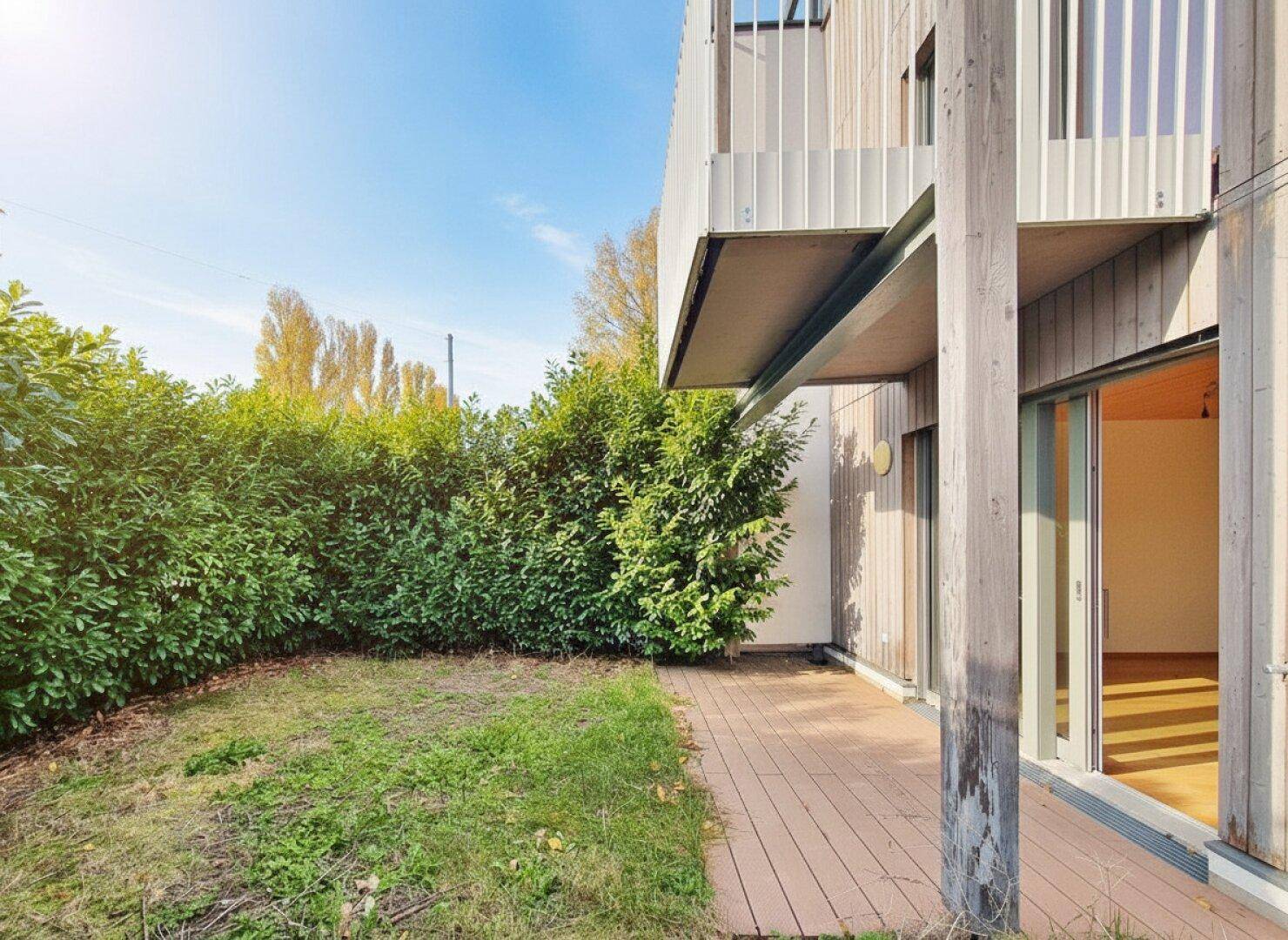 Kleiner Gartenbereich mit Rasen und hoher Hecke, bietet Privatsphäre und Grünblick.