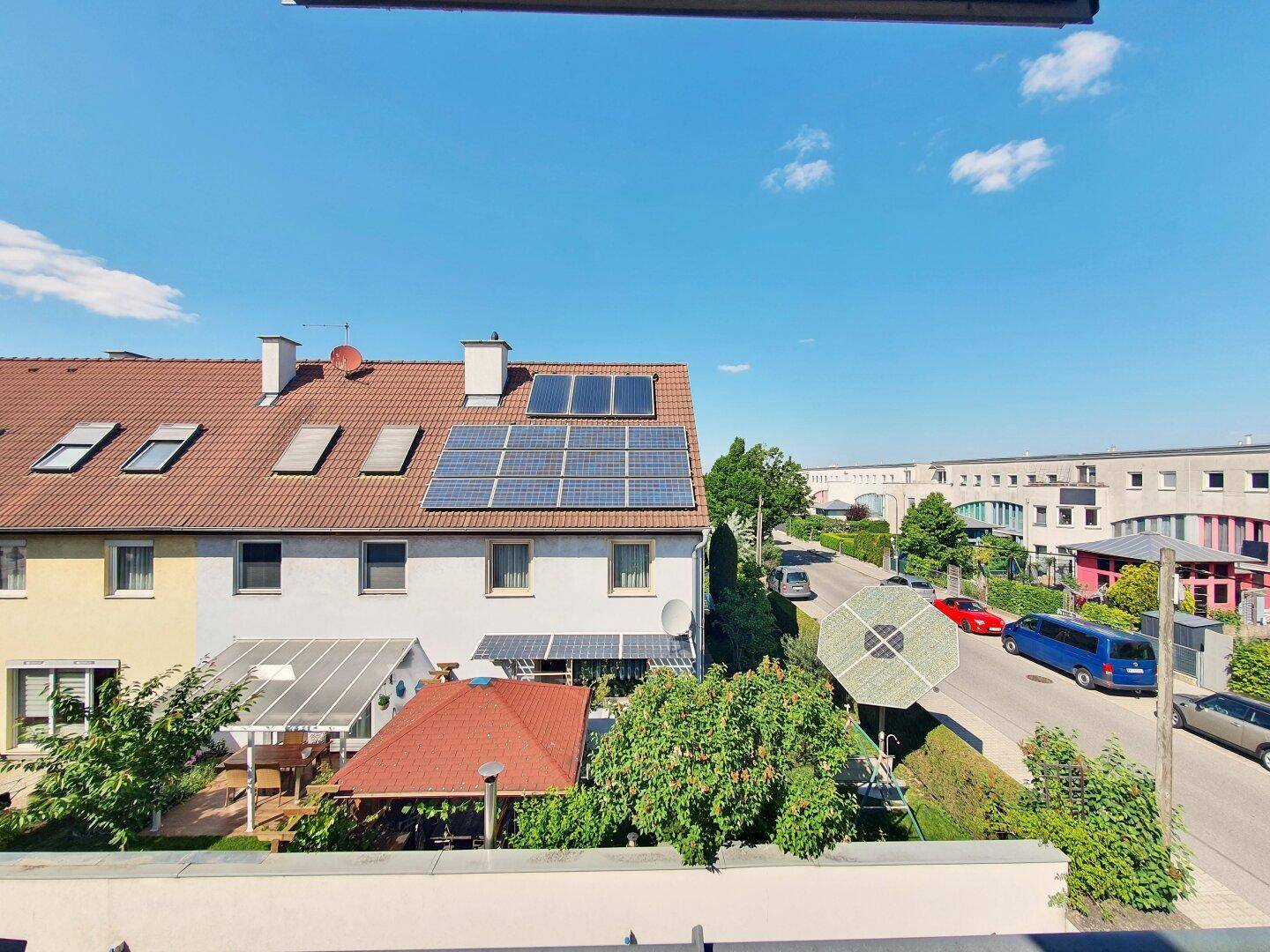 Weitblick über benachbarte Dächer mit Solaranlagen und die umliegende Bebauung.