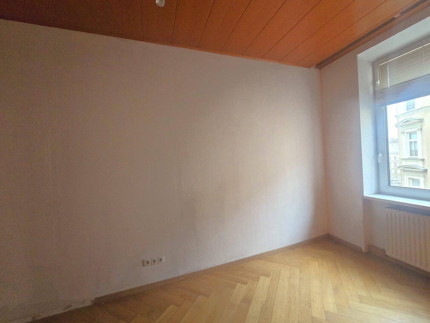 Ruhiges Zimmer mit Fischgrätparkett und Holzdecke, ideal als Schlaf- oder Arbeitszimmer.