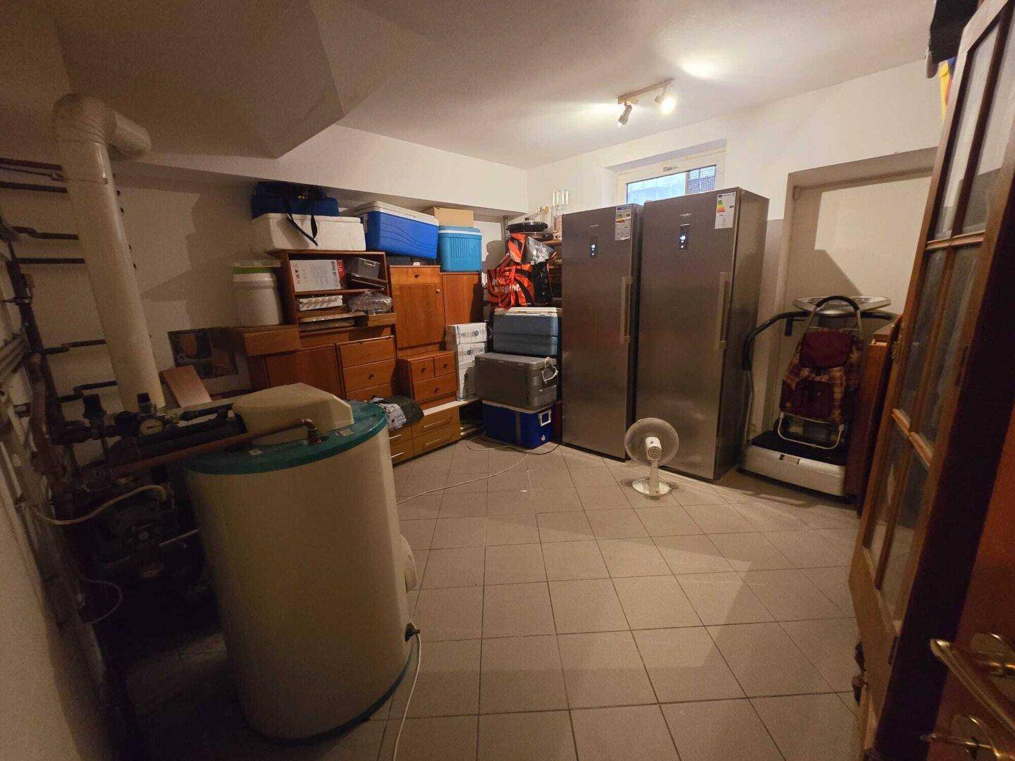 Geräumiger Abstellraum im Untergeschoss mit Fliesenboden und Heizungsanlage.