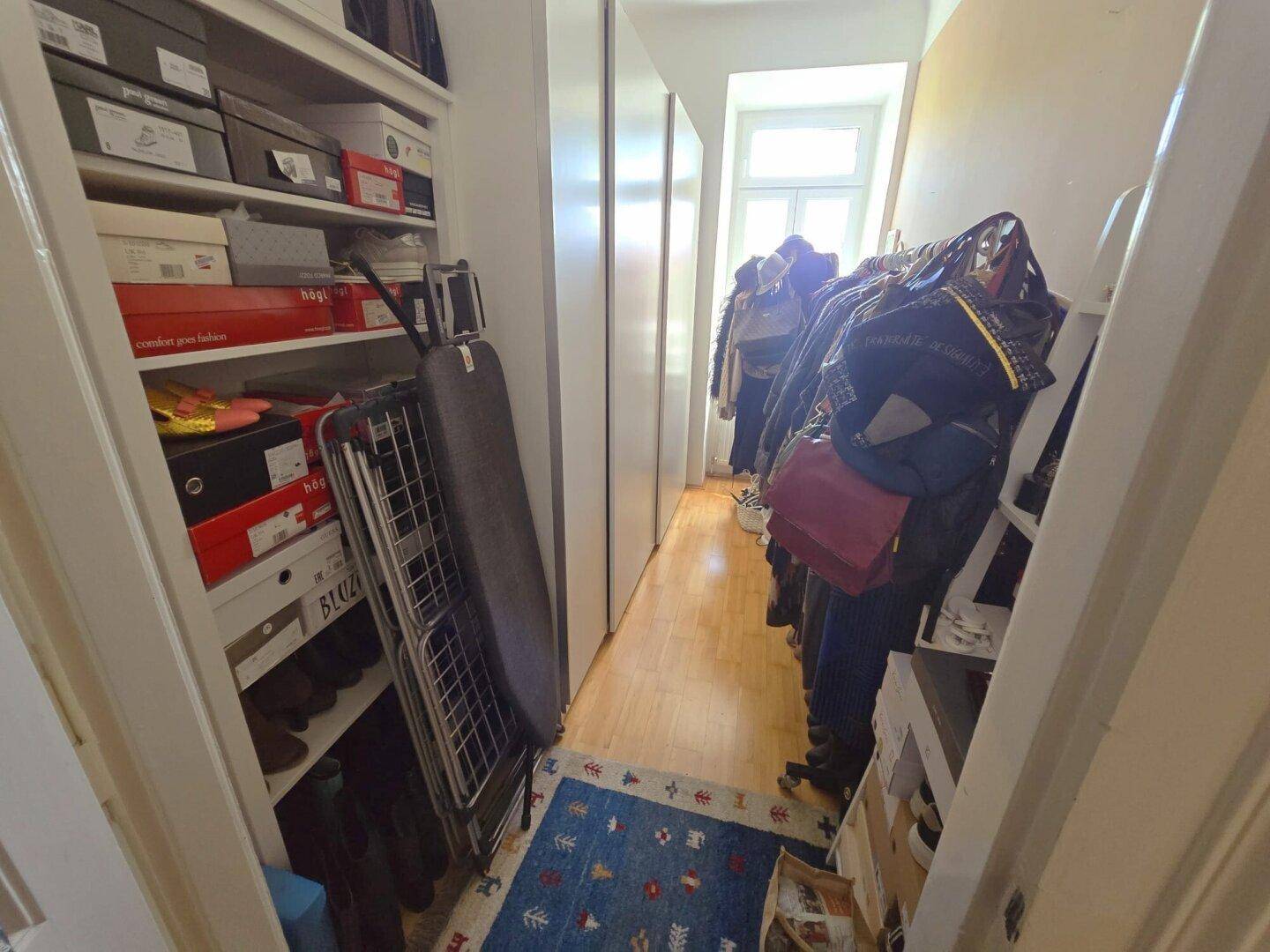 Praktischer Abstellraum mit Regalen und Kleiderstangen für zusätzlichen Stauraum.