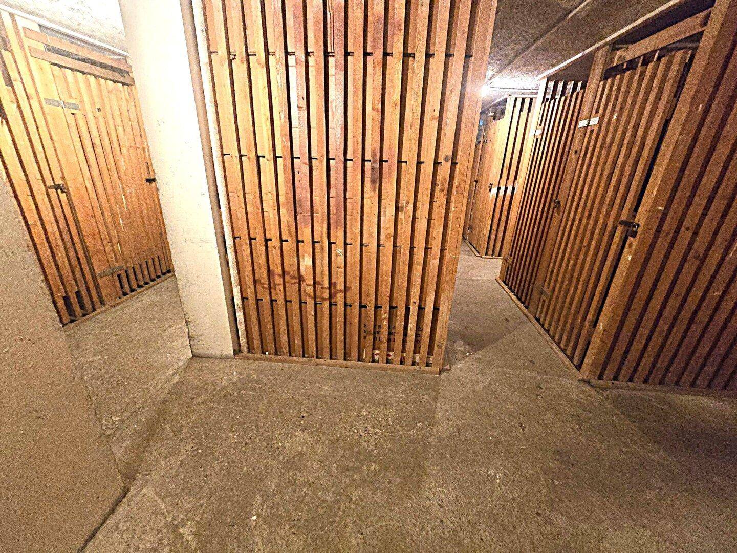 Kellerabteile mit Holzverschlägen, bieten zusätzlichen Stauraum für Bewohner.
