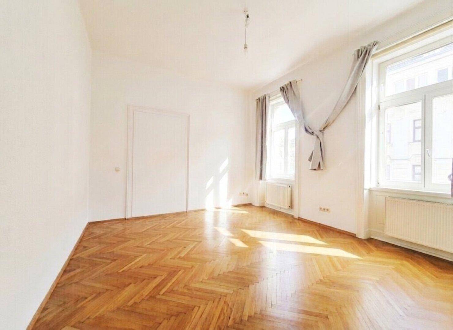 Geräumiges Zimmer mit klassischem Fischgrätparkett und hellen Wänden, ideal für individuelle Gestaltung.