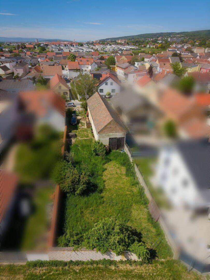 Luftaufnahme des Grundstücks mit angrenzendem Gebäude und Blick auf die umliegende Wohnsiedlung.