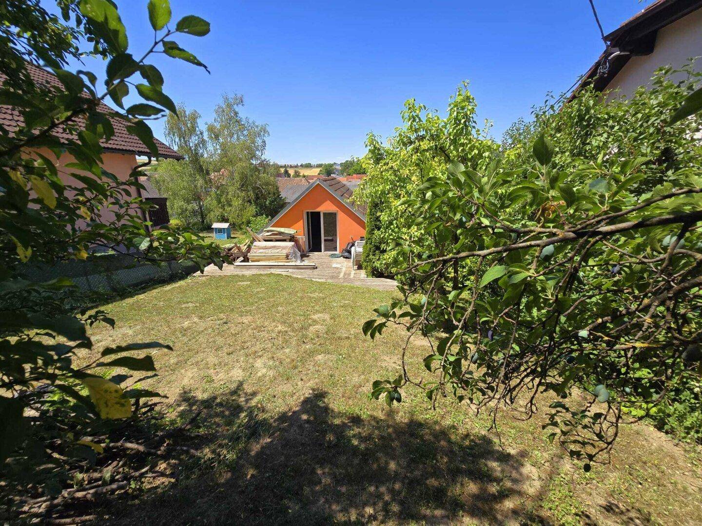 Großer Garten mit Rasenfläche und Blick auf das Haus in der Ferne.