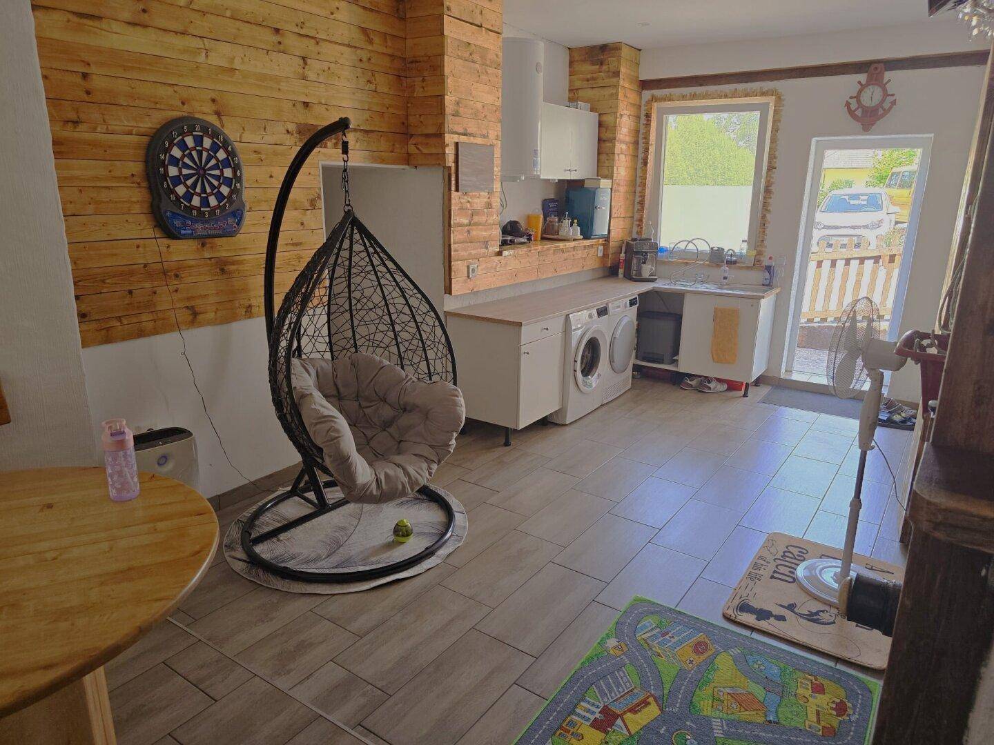 Rustikaler Küchen- und Hauswirtschaftsbereich mit Waschmaschinen und Holzverkleidung.