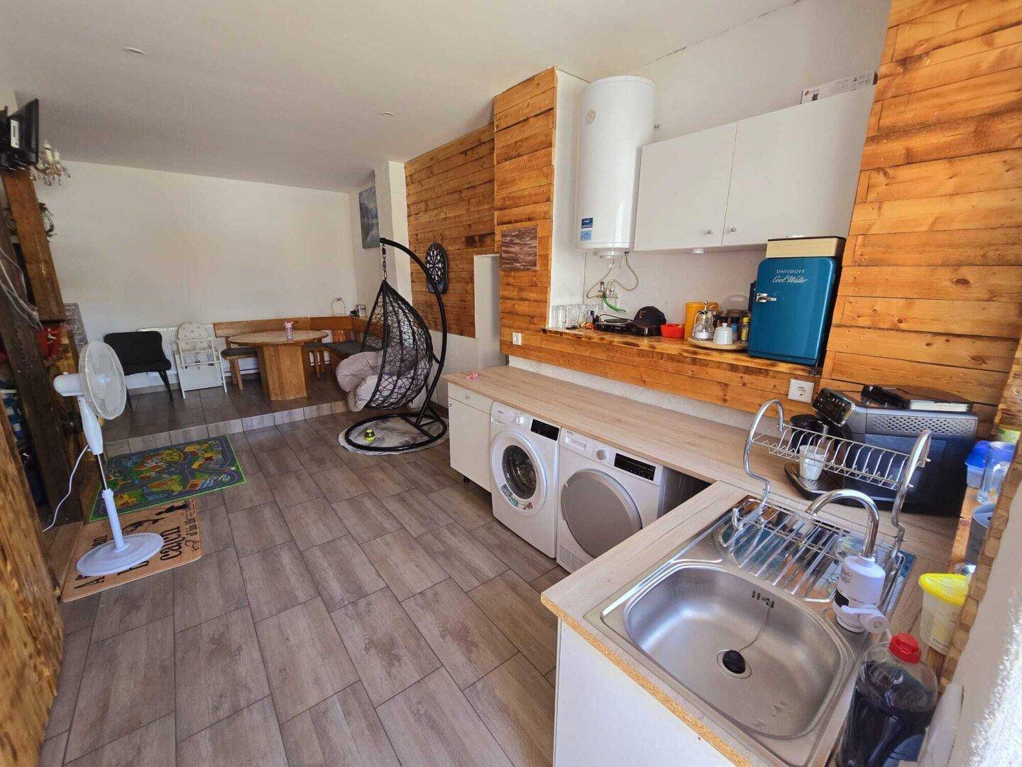 Rustikaler Küchen- und Hauswirtschaftsbereich mit Waschmaschinen und Holzverkleidung.