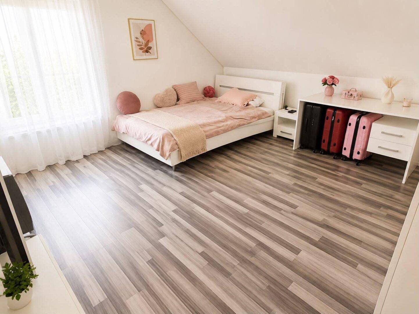Helles Schlafzimmer mit Laminatboden, Dachschräge und einem großen Fenster für viel Licht.