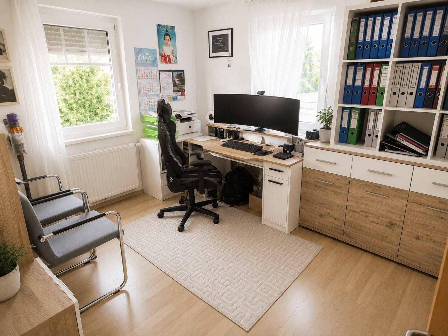 Funktionales Heimbüro mit großem Schreibtisch, Bürostuhl und viel Stauraum.