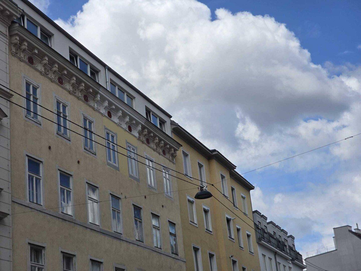 Historische Gebäudefassade mit vielen Fenstern und dekorativen architektonischen Details.