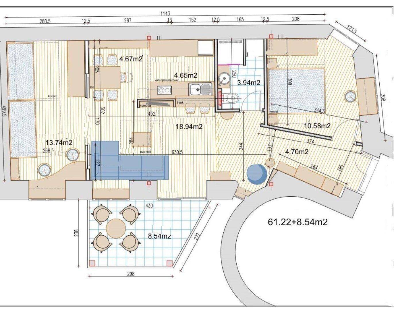 Grundriss einer Wohnung mit offenem Wohnbereich, einem Schlafzimmer, Bad, separatem WC und großer Terrasse mit Sitzgelegenheiten.
