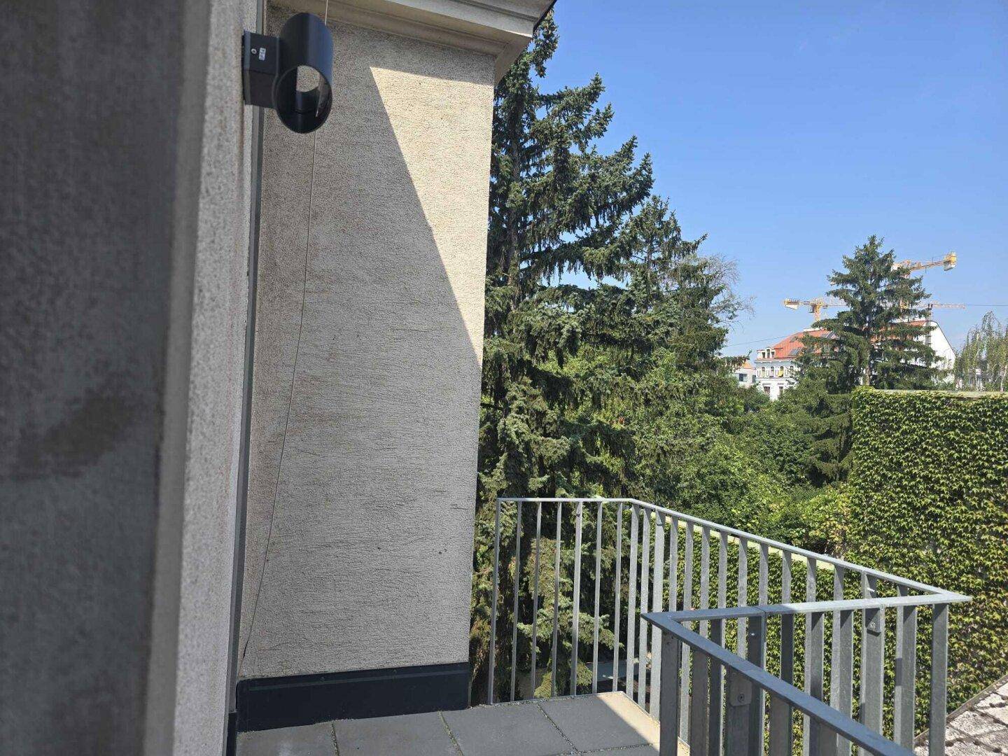 Balkon mit grüner Aussicht auf Bäume und die Umgebung, ausgestattet mit einem Metallgeländer.