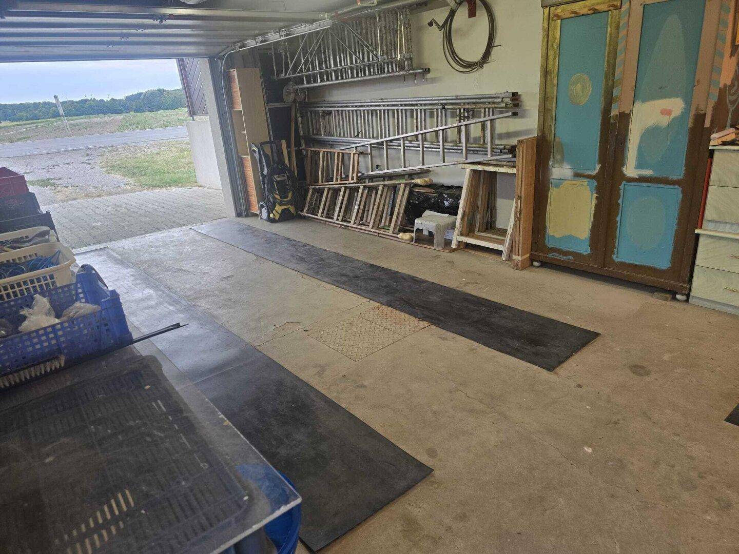 Geräumige Garage mit viel Stauraum, Leitern und Werkzeugen.