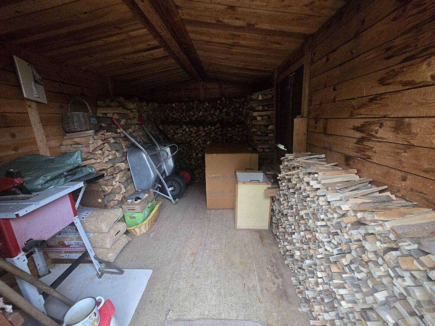 Holzschuppen gefüllt mit Brennholz, bereit für den Winter.