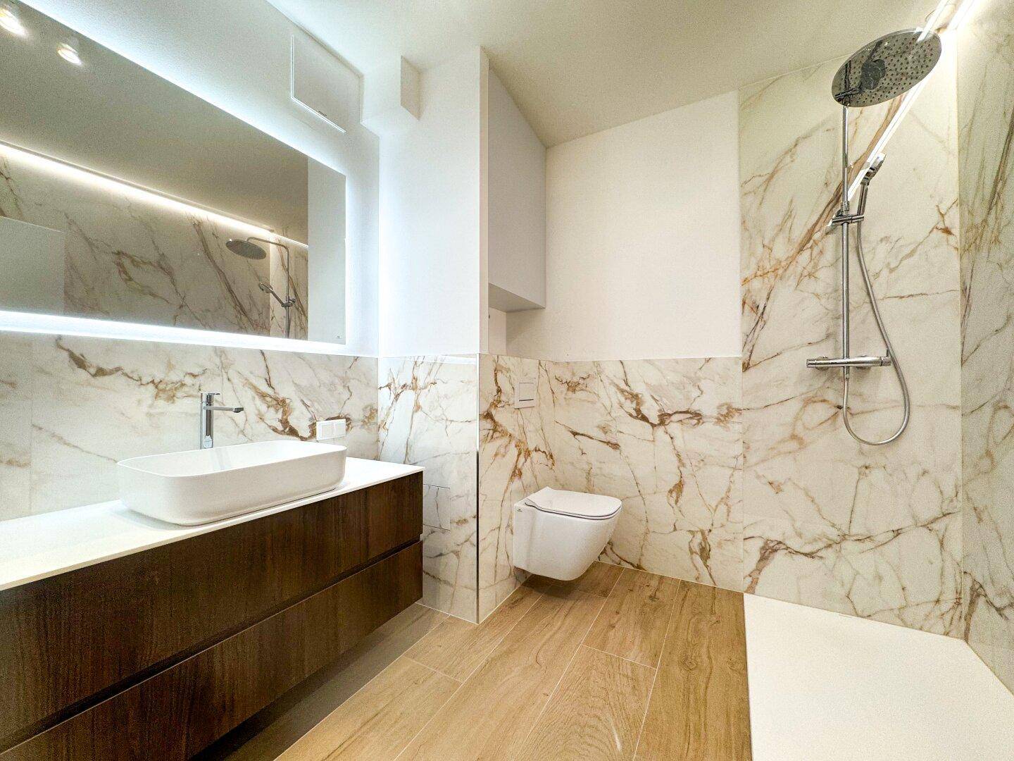 Modernes Badezimmer mit Marmorfliesen, Holzwaschtisch und großer begehbarer Dusche.