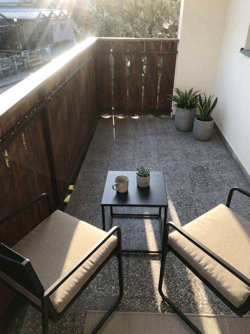 Sonniger Balkon mit Sitzgelegenheiten und Pflanzen, ideal zum Entspannen im Freien.