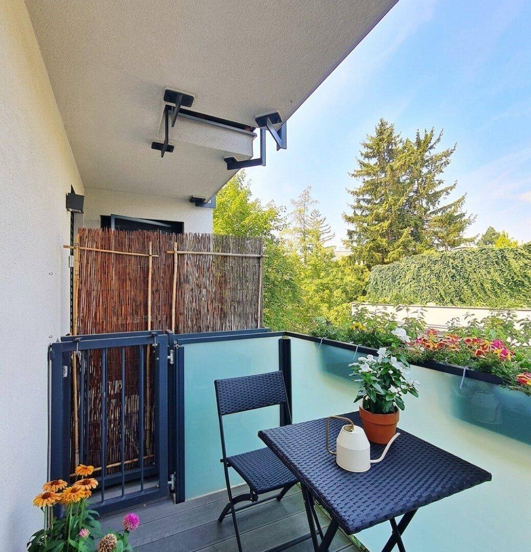 Gemütlicher Balkon mit Pflanzen und Sichtschutz, perfekt für private Momente im Freien.
