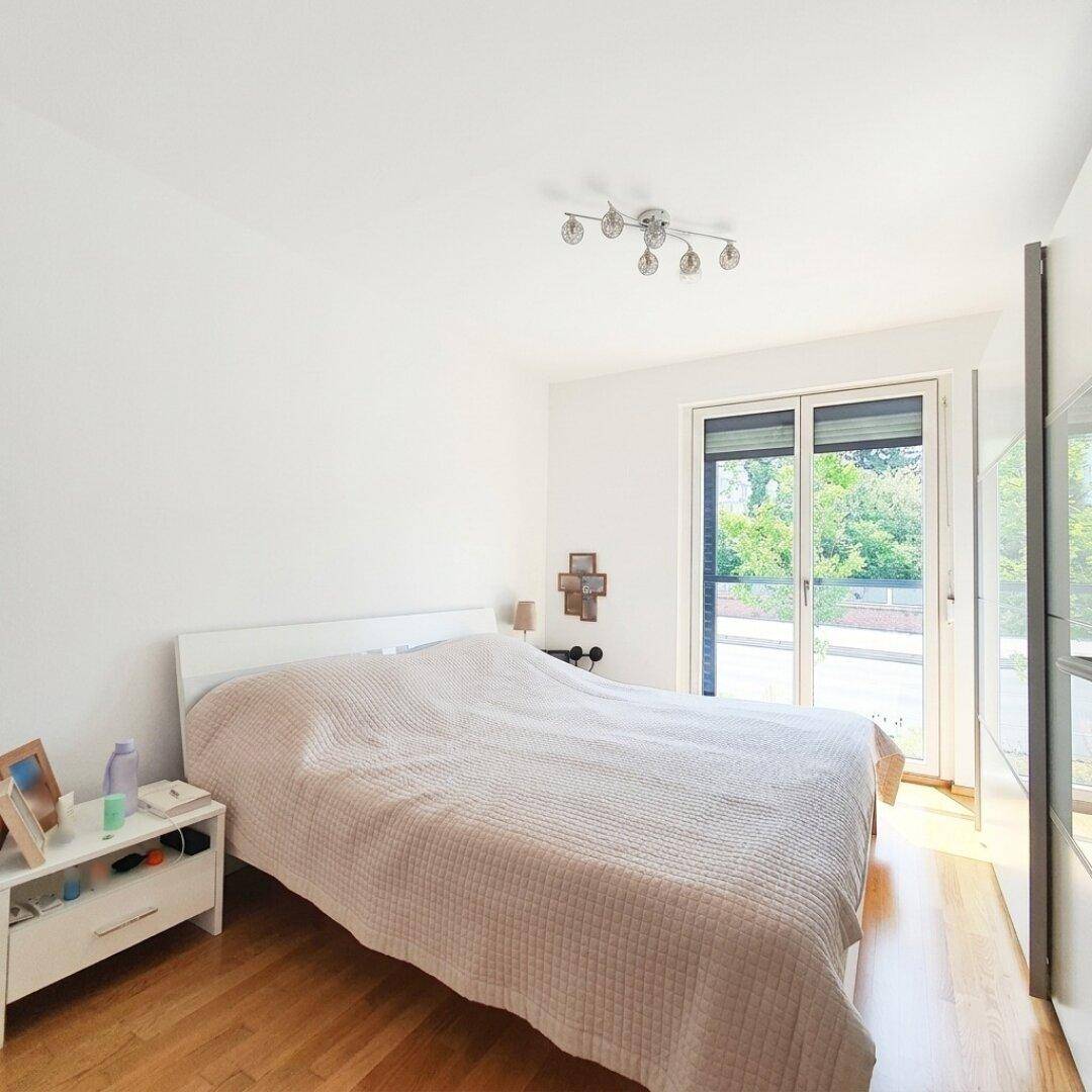 Gemütliches Schlafzimmer mit Doppelbett, Holzboden und Zugang zum Balkon.