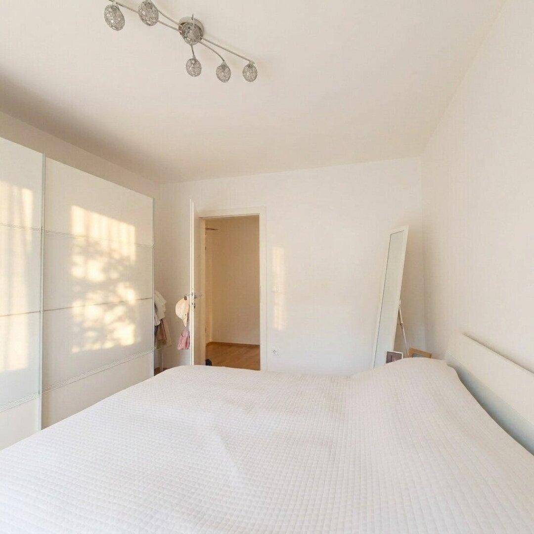 Helles Schlafzimmer mit großem Kleiderschrank und Holzboden, bietet viel Stauraum.