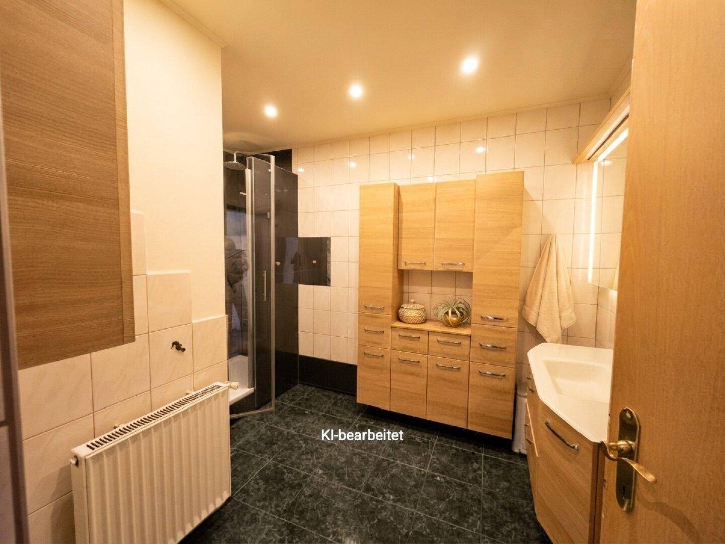 Badezimmer mit dunklen Bodenfliesen, weißer Wandverkleidung, Duschkabine und Holzwaschtisch.