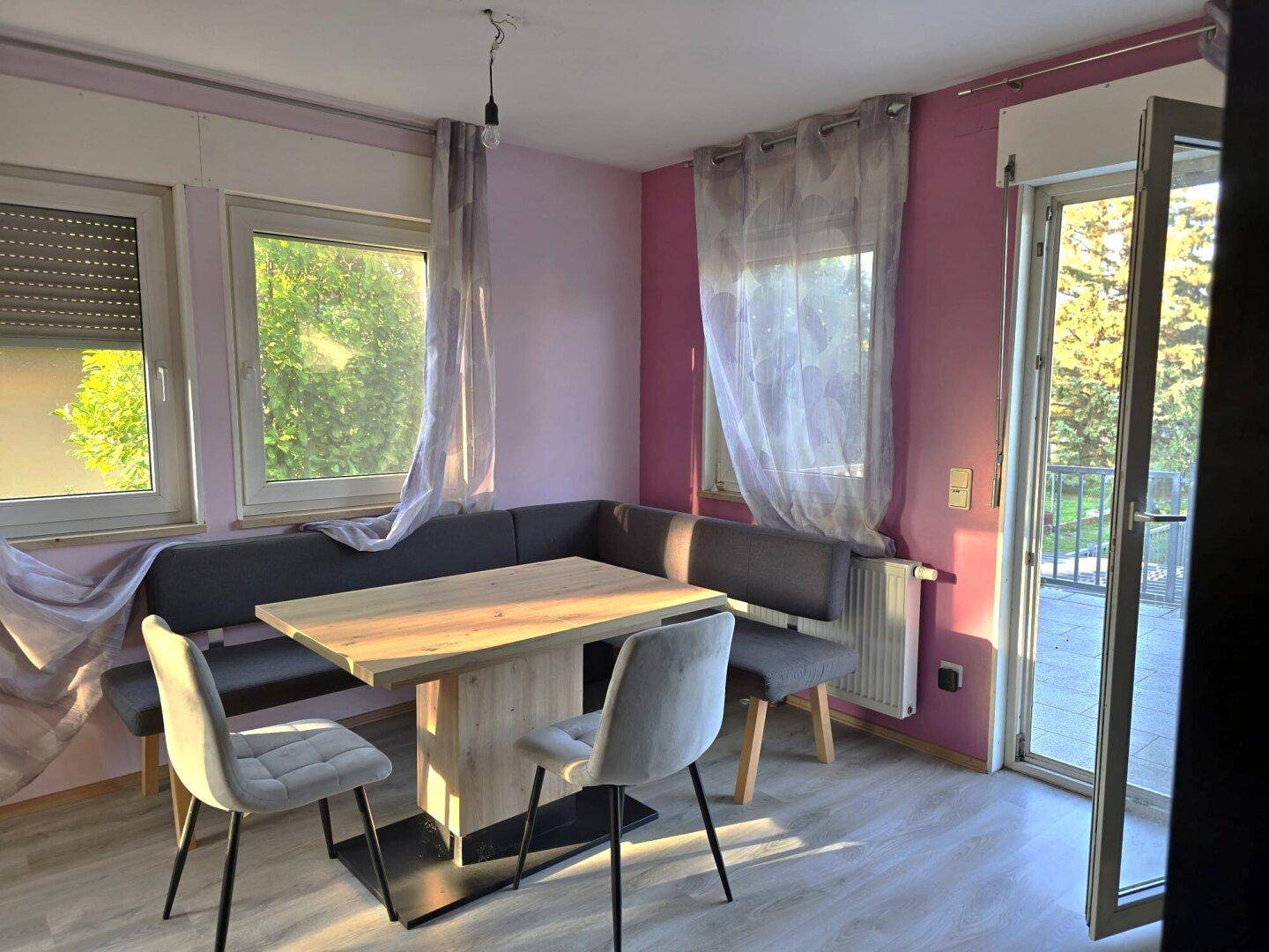 Heller Essbereich mit Eckbank, Holztisch und Zugang zur Terrasse.