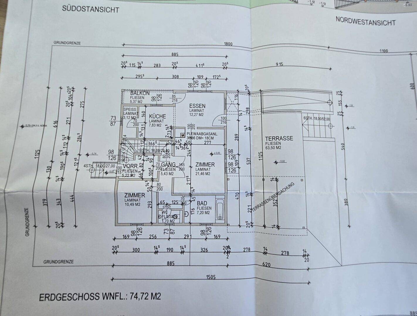 Grundriss des Erdgeschosses mit offener Küche, Essbereich, Zimmer und großer Terrasse.